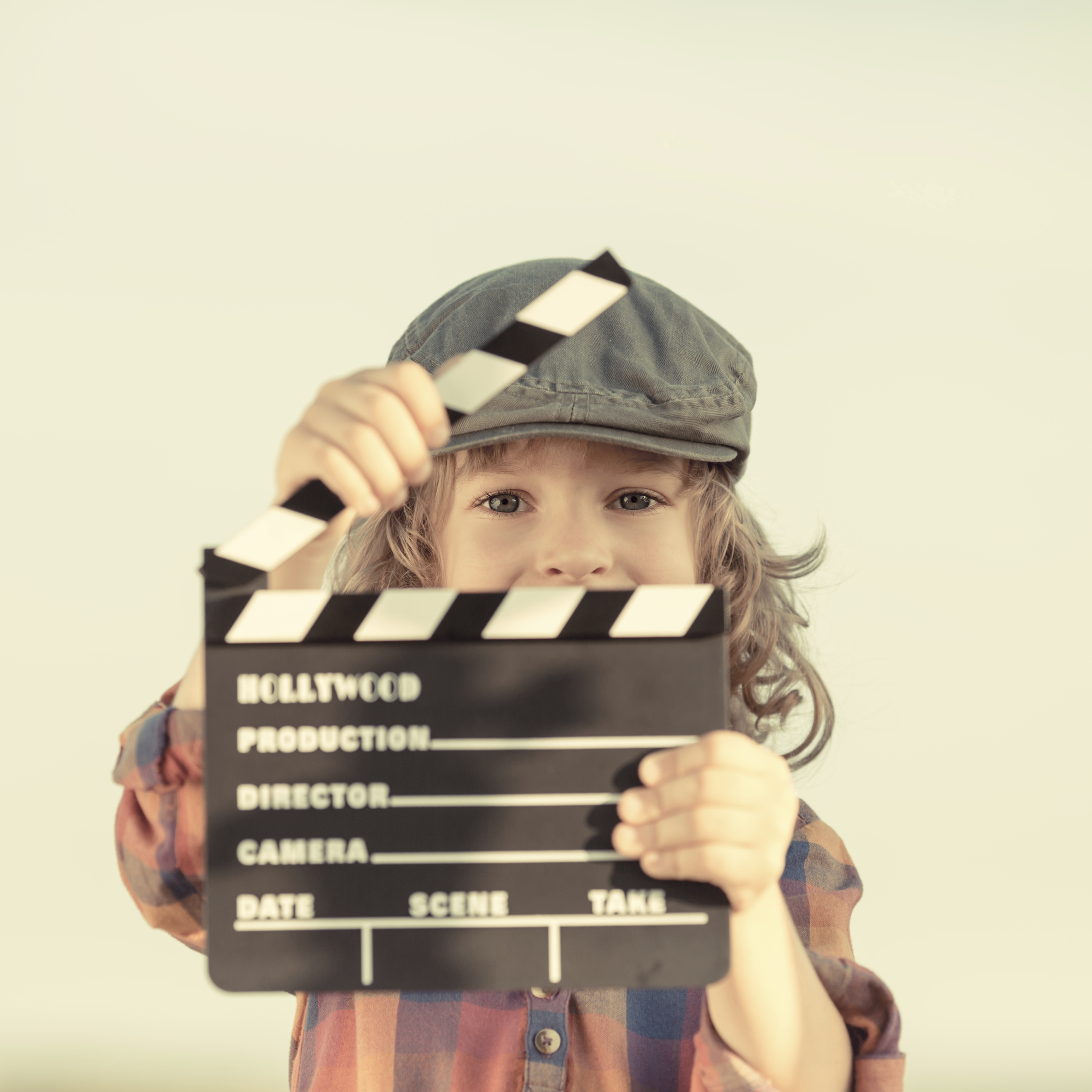 Kid holding clapper board in hands